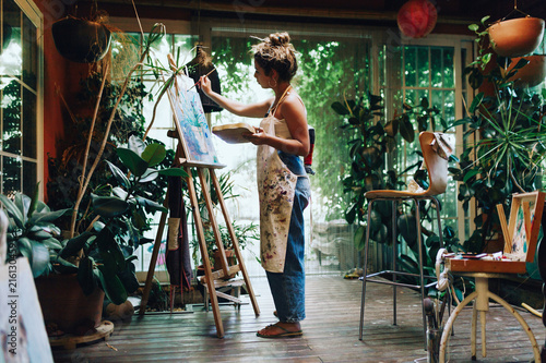 Woman drawing on a camvas in art studio photo