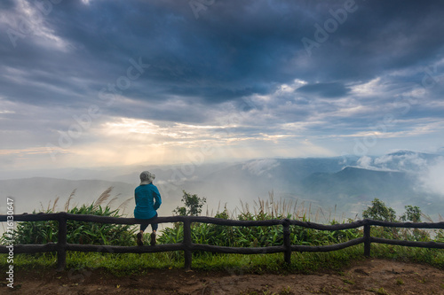 The girl in blue jacket touring on Phu-Ruea mountain. Thailand.
