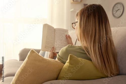 Young woman reading book on...