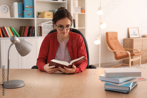 Young woman reading book at...