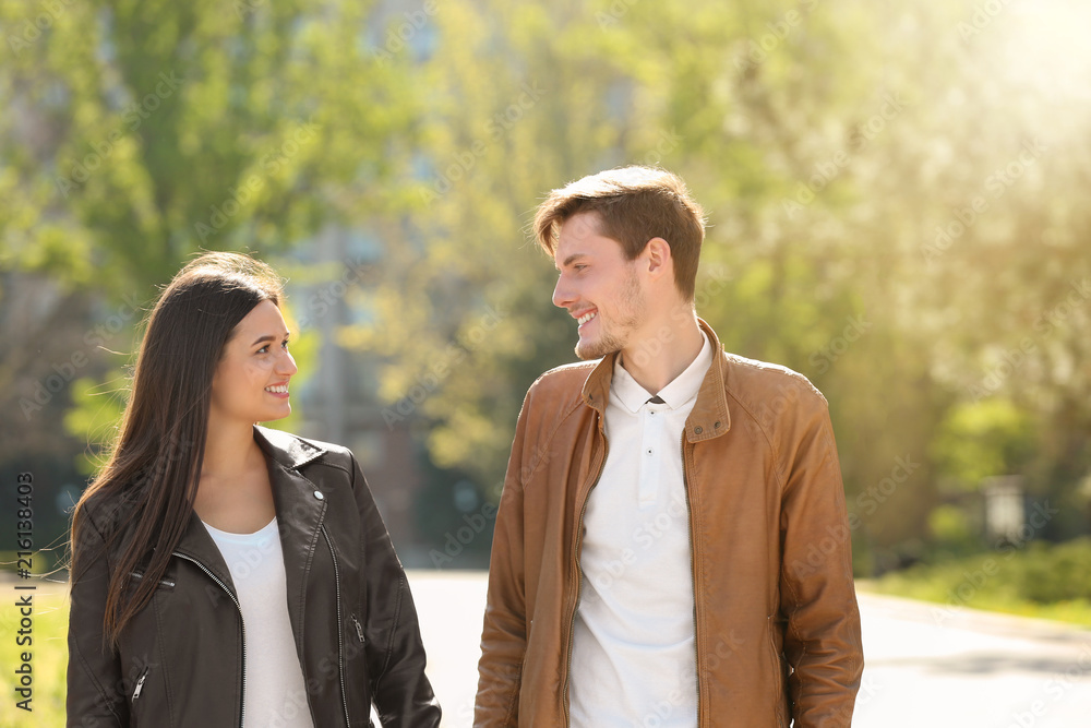 Happy young couple walking together in city park Happy young couple walking together in city park