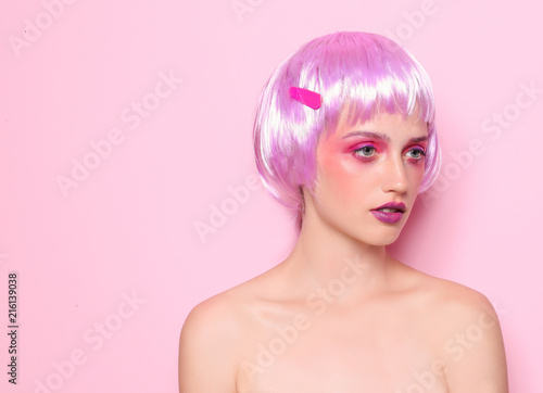 Young woman with unusual hair and professional makeup on color background