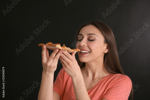 Young woman eating slice of...