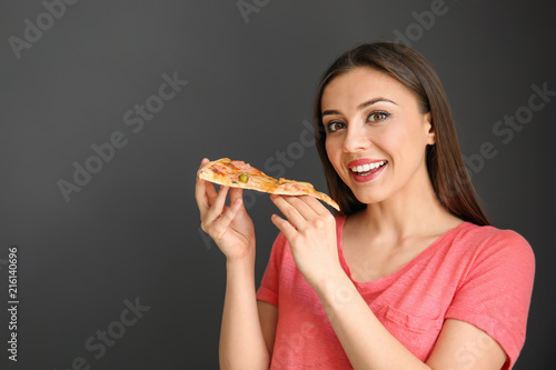 Young woman eating slice of...