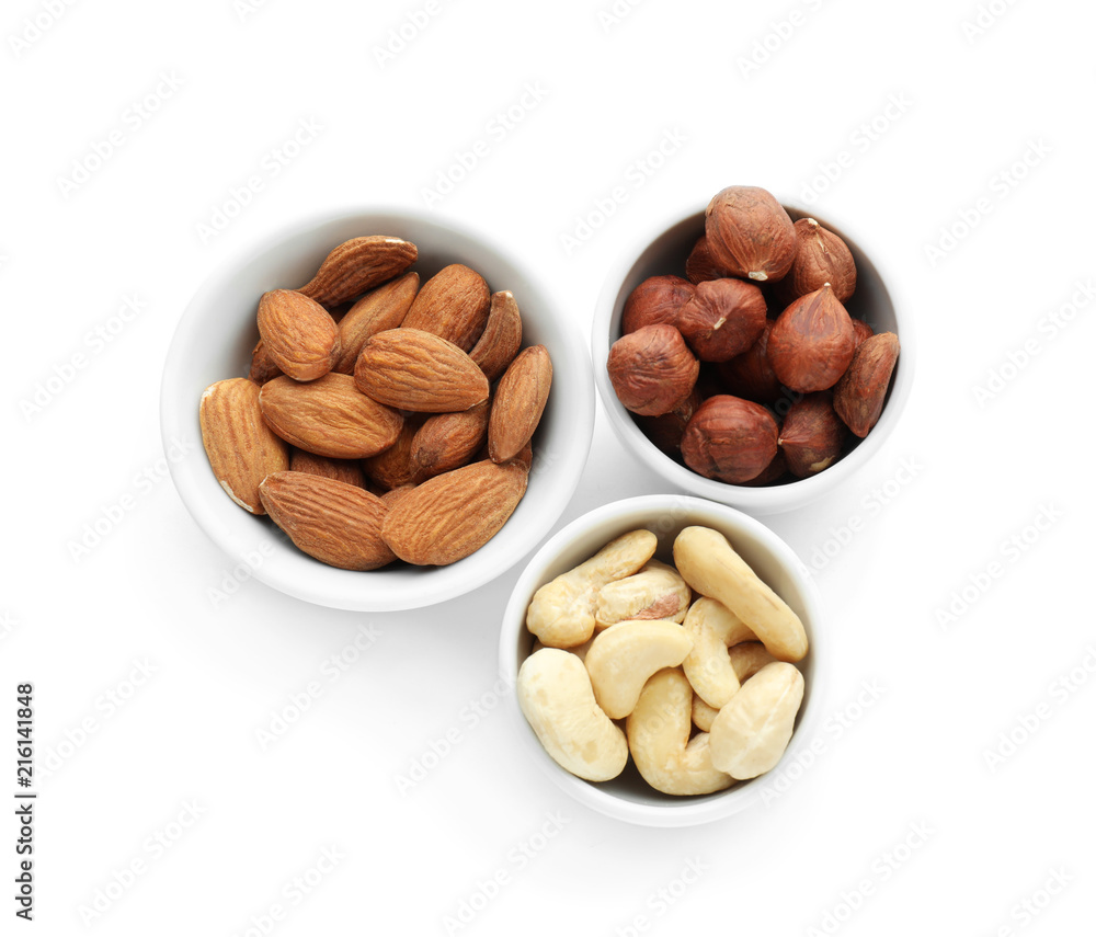 Bowls with different nuts on white background Bowls with different nuts on white background