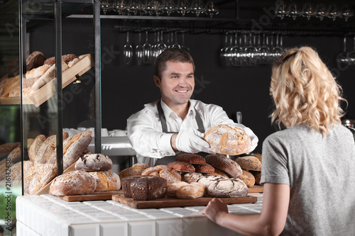 Woman buying fresh bread fr...