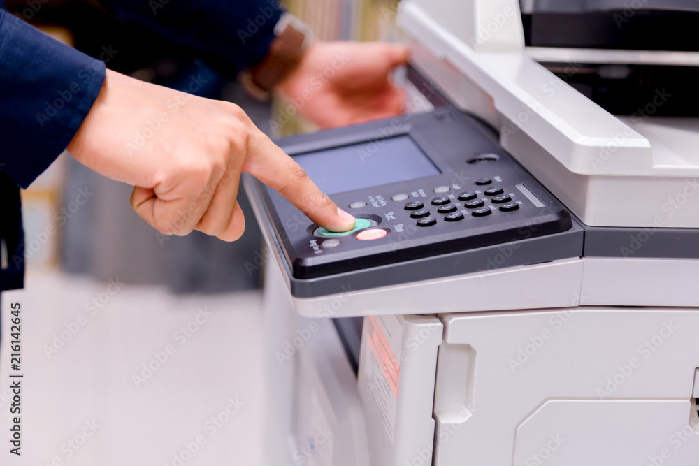 Close-up bussiness man Hand press button on panel of printer, printer scanner laser office copy machine supplies start concept.