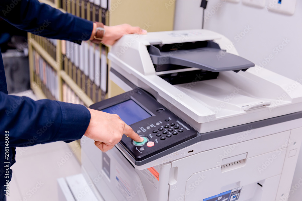 Bussiness man Hand press button on panel of printer, printer scanner laser office copy machine supplies start concept. Bussiness man Hand press button on panel of printer, printer scanner laser office copy machine supplies start concept.