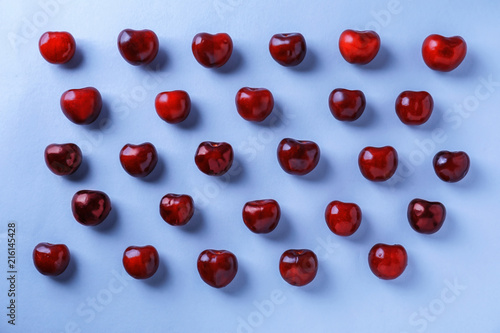 Flat lay composition with ripe cherries on color background