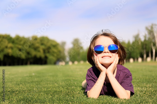 Cute little boy relaxing in park on sunny day © Pixel-Shot