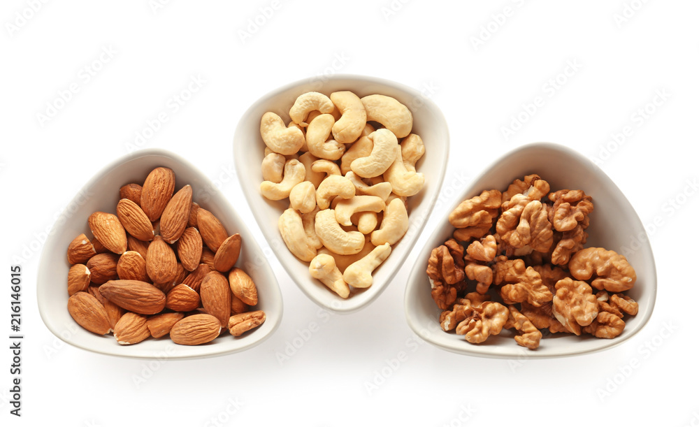 Bowls with tasty nuts on white background Bowls with tasty nuts on white background