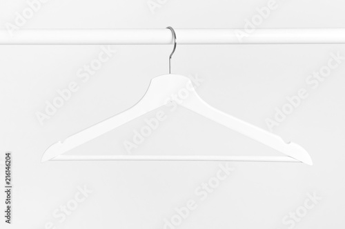One white wooden hanger without clothes on background of white wall. Soft focus. Store concept, sale, design, empty hanger.