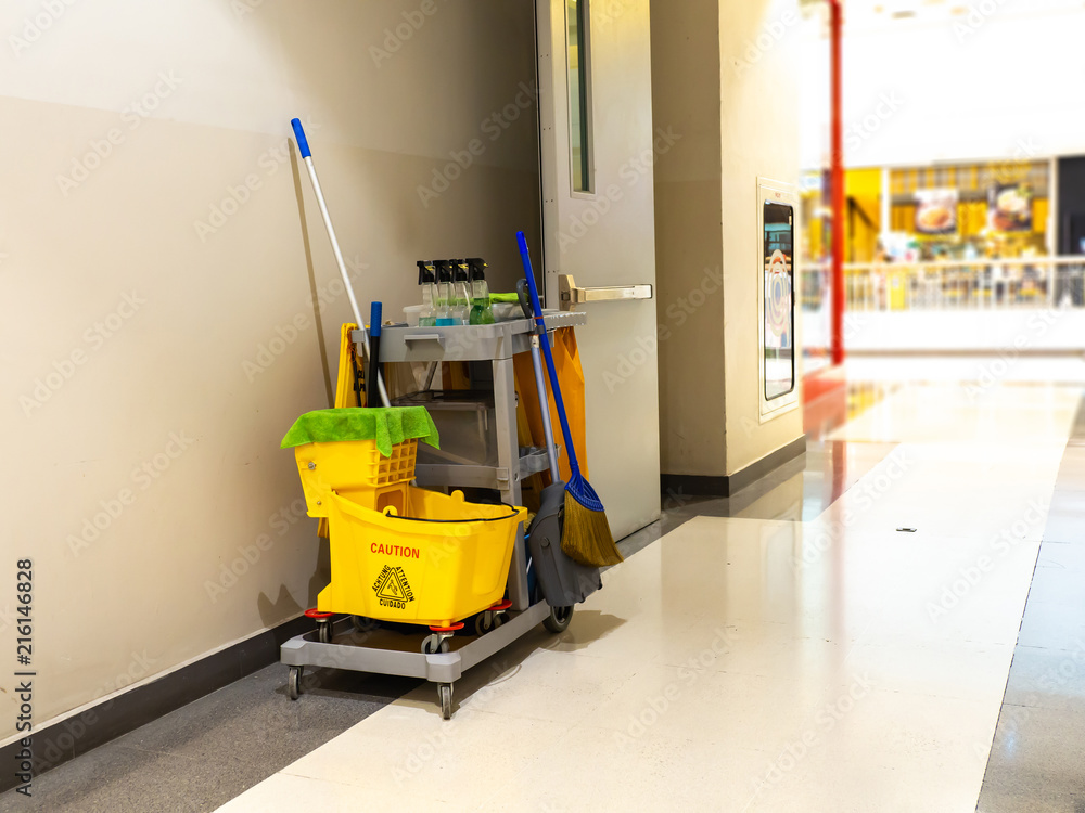 Cleaning tools cart wait for maid or cleaner in the department store. Bucket and set of cleaning equipment in the mall. Concept of service, worker and equipment for cleaner and health Cleaning tools cart wait for maid or cleaner in the department store. Bucket and set of cleaning equipment in the mall. Concept of service, worker and equipment for cleaner and health