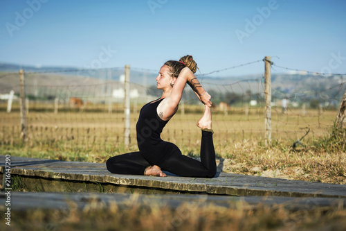 Woman on Los Lances beach doing a king pigeon yoga pose, The Strait Natural Park, Tarifa, Cadiz, Andalusia, Spain photo