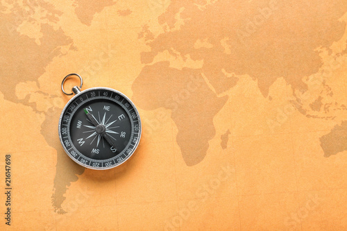 Modern compass on vintage world map. Travel planning concept