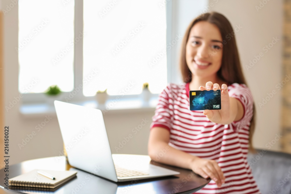 Young woman shopping online with credit card and laptop in cafe Young woman shopping online with credit card and laptop in cafe