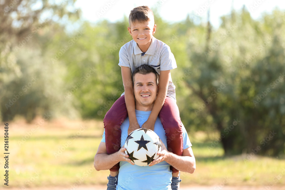 Obraz premium Father and son playing soccer outdoors, family bonding and childhood happiness, active lifestyle and sports recreation