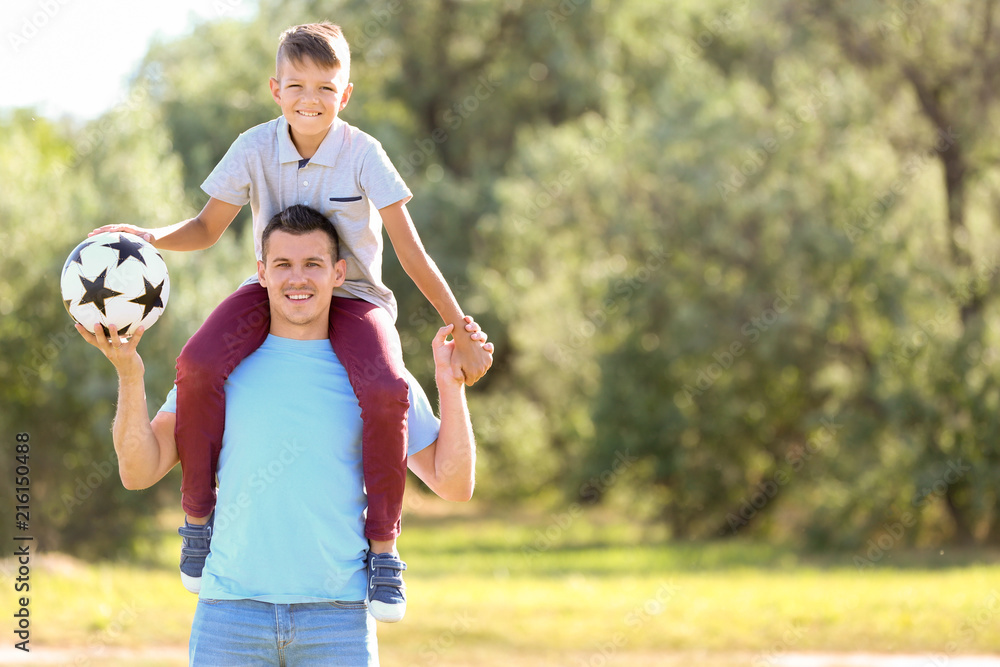 Obraz premium Little boy and his dad with soccer ball outdoors