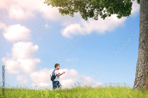 Portrait of school kids running on the grass floor under the tree.