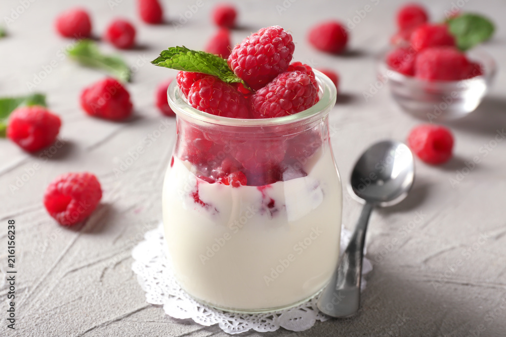 Glass jar with tasty raspberry dessert on table Glass jar with tasty raspberry dessert on table