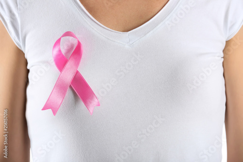 Beautiful woman with pink ribbon on t-shirt, closeup. Breast cancer concept