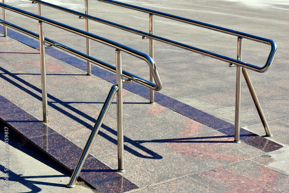 ramp with stainless steel fencing and chrome-plated metal structures for disabled wheelchair users, trolleys with cargo and gods ramp with stainless steel fencing and chrome-plated metal structures for disabled wheelchair users, trolleys with cargo and gods
