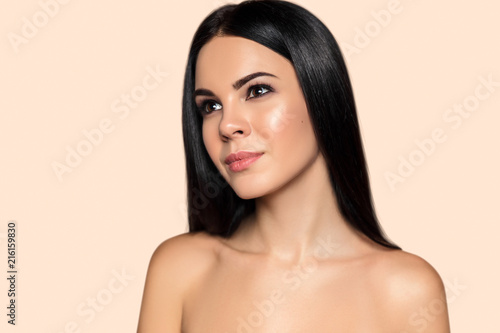 Beauty portrait of young brunette woman with perfect healthy skin and smooth hait. Attractive model with natural professional make up. Hairdress salon and cosmetics concept