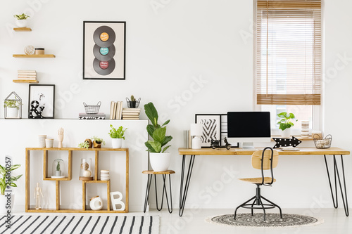 Hipster, white home office interior with natural, wooden furniture, industrial elements, green plants and a computer on a big desk © Photographee.eu