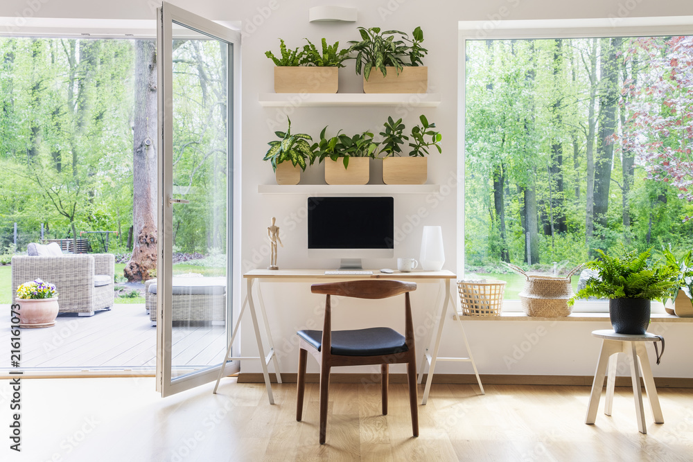 Zen home office with computer in a beautiful, spacious living room interior  with plants and an outside view through big windows Stock-Foto | Adobe Stock