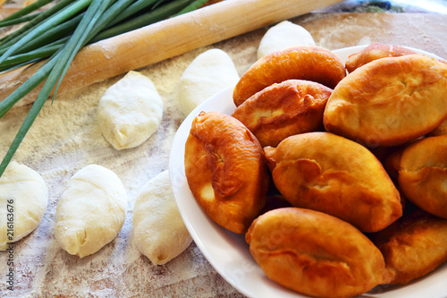 Process of preparation of patties. The filling consists of onions and eggs. Pirozhok - a dish of Russian and European cuisine from the dough with stuffing. Selective focus, copy space.