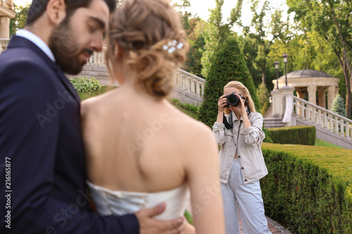 Fotografie Professional photographer taking photo of wedding couple outdoors