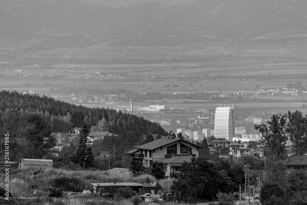 Black and white scenery landscape elevated view of Eastern Sofia and the airport in a summer day with haze in the air. Vitosha mountain, Bulgaria