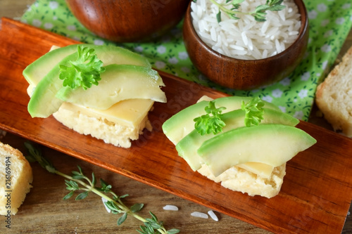 Sandwiches with cheese and avocado slices on pieces of rice gluten free bread