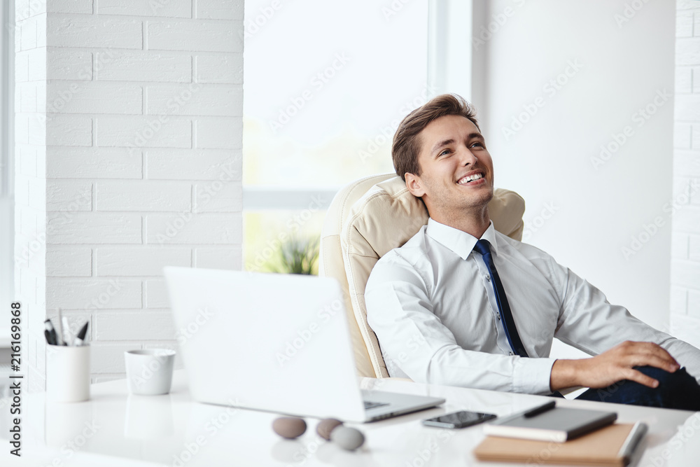 Young handsome businessman smiling in a modern office Young handsome businessman smiling in a modern office