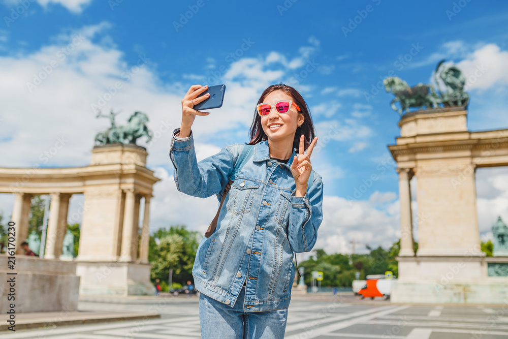 An Asian woman tourist on one of the main attractions of Budapest - Heroes Square. Concept travel throughout Europe and Hungary