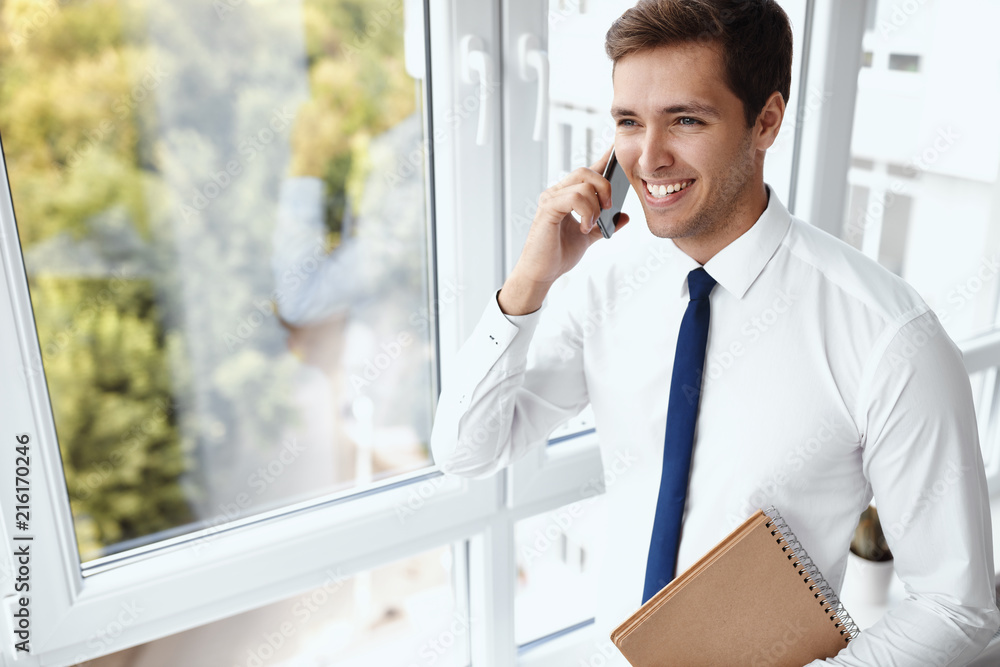 Fototapeta premium Young handsome businessman working in a modern office
