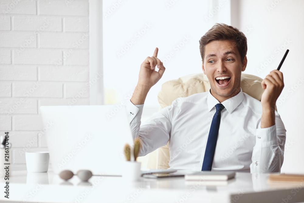 Young handsome businessman smiling in a modern office Young handsome businessman smiling in a modern office