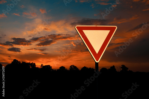 Yield Sign with Sunset Sky on Background