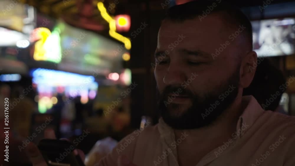 Handsome man sitting in the bar and browsing internet on smartphone
Handsome man sitting in the bar and browsing internet on smartphone