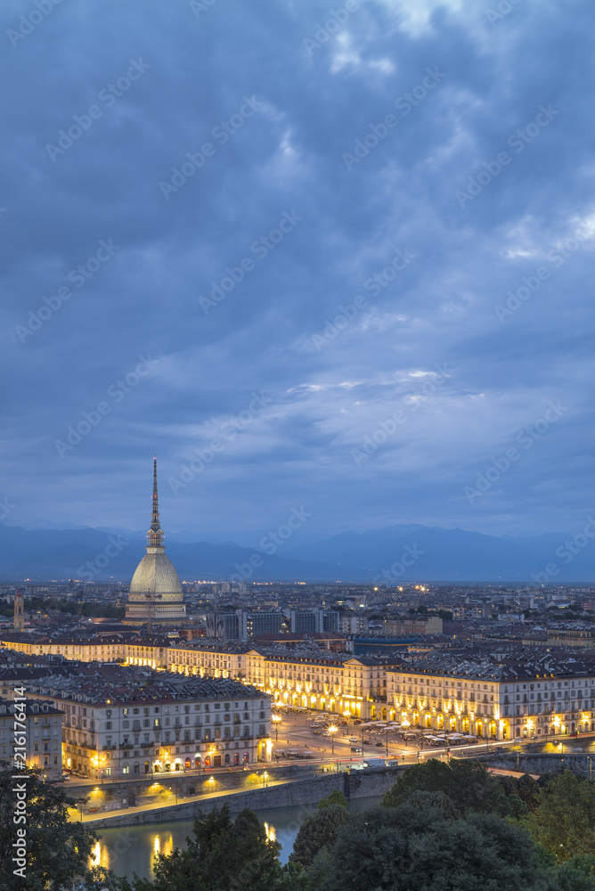 blue evening and golden city lights in Turin in summer day in Italy