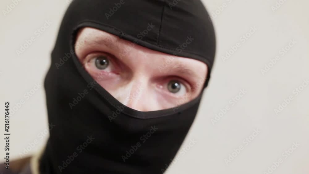 man in black mask looks at camera man in black mask looks at camera