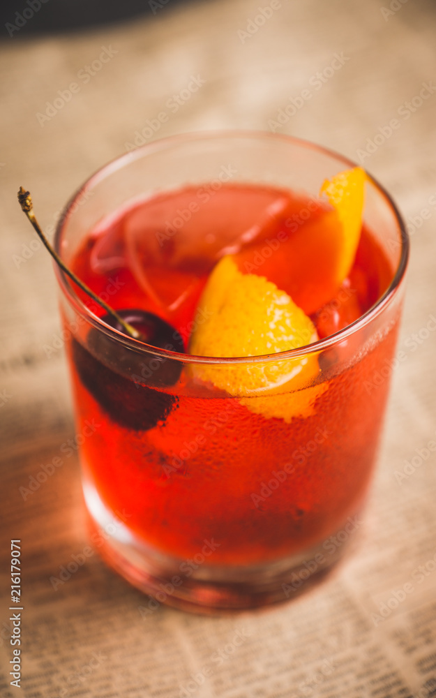 Old fashioned cocktail with cherry and orange peel. Selective focus. Old fashioned cocktail with cherry and orange peel. Selective focus.