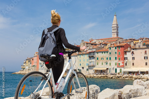 Fotografie Young active female tourist cycling and enjoiying beautiful view of Rovinj, Istria, Croatia