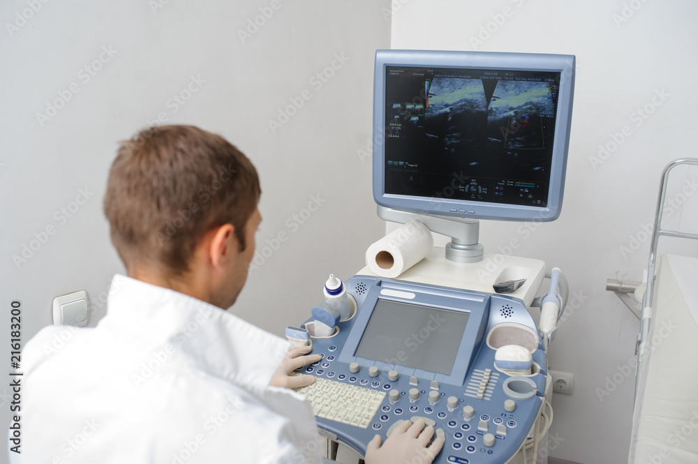 The doctor using the ultrasonography device The doctor using the ultrasonography device