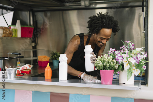 Smiling food vendor hands food to waiting customer photo