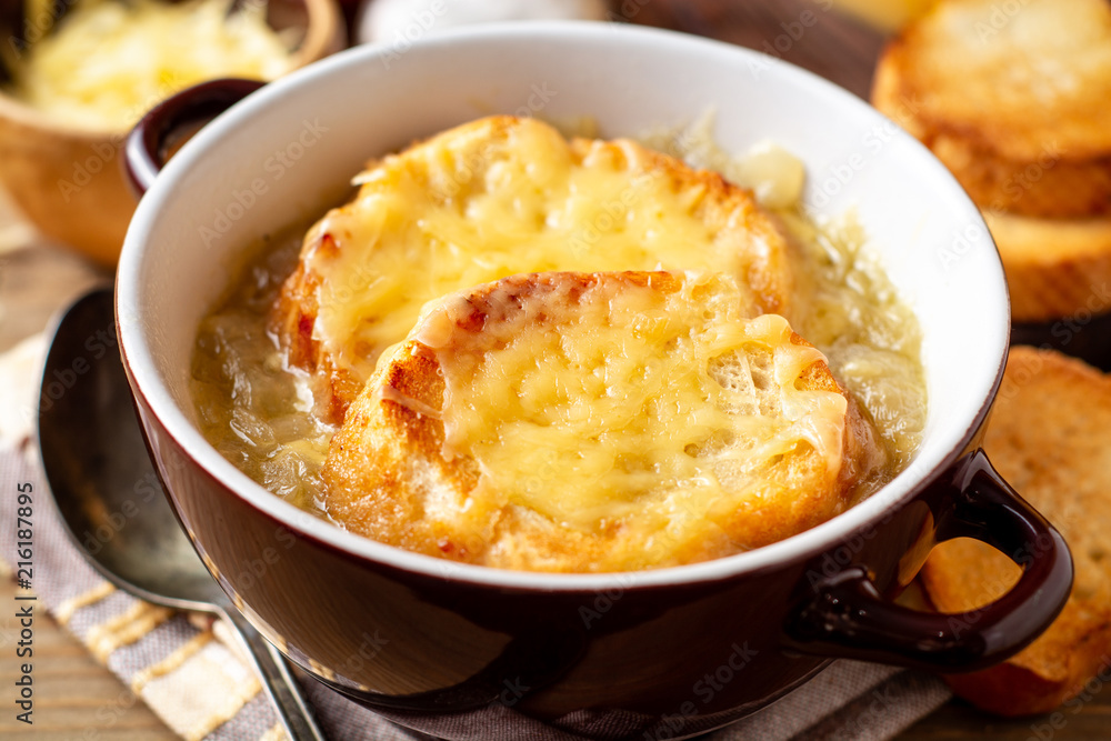 French onion soup with croutons and cheese on rustic wooden table French onion soup with croutons and cheese on rustic wooden table