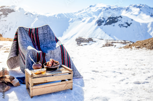 Winter picnic in chilean argentine snow mountaines Andes with hot meat food and drink yerba mate.