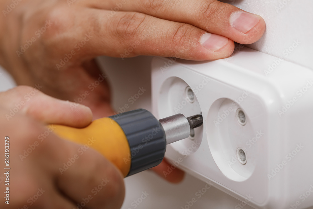 electrician installing electrical socket - obrazy, fototapety, plakaty 