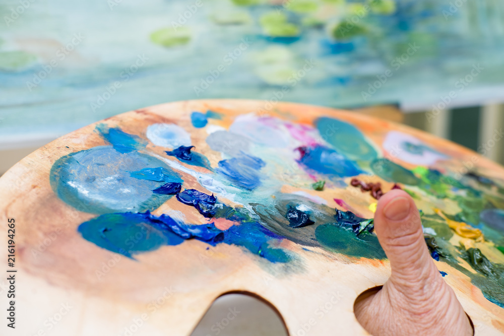artist holding palette of oil paint