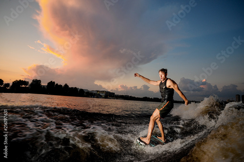 Active man riding on wakesurf down the river © fesenko